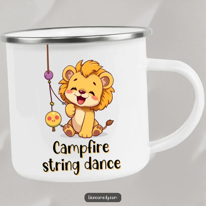 Funny lion cub camping mug illustrating a cub joyfully batting at a dangling string toy with its paws, full of playful energy.