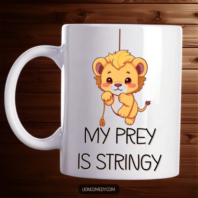 Funny kawaii lion cub mug showing a cute, fluffy cub joyfully pouncing on a dangling string, full of playful energy and charm.
