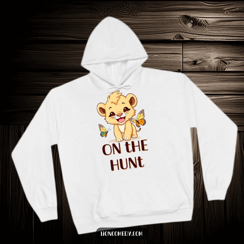 Funny Lion Cub Hoodie, a cute lion cub with a wide grin, playfully chasing a butterfly, perfect for cozy wear.