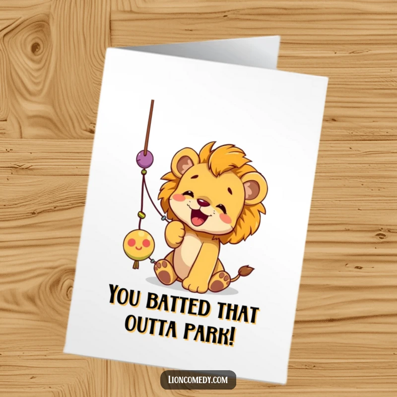 Funny Free Printable Congratulations Card with a playful lion cub enthusiastically batting at a swinging string toy.